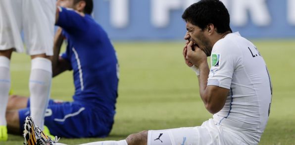 Uruguajčan Luis Suarez (vpravo) si kontroluje zuby po kontakte s talianskym hráčom Giorgiom Chiellinim. (Zdroj: TASR/AP)