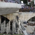  Robotníci stoja nad zrútenou časťou mosta v brazílskom meste Belo Horizonte. (Zdroj: TASR)