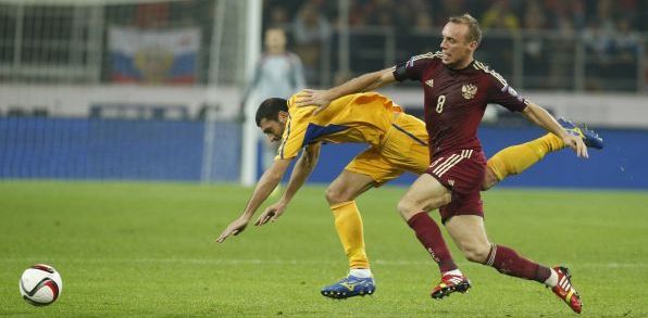 Ruský hráč Denis Glušakov (vpravo) bojuje o loptu s Alexandru Gatcanom z Moldavska (zdroj: TASR)